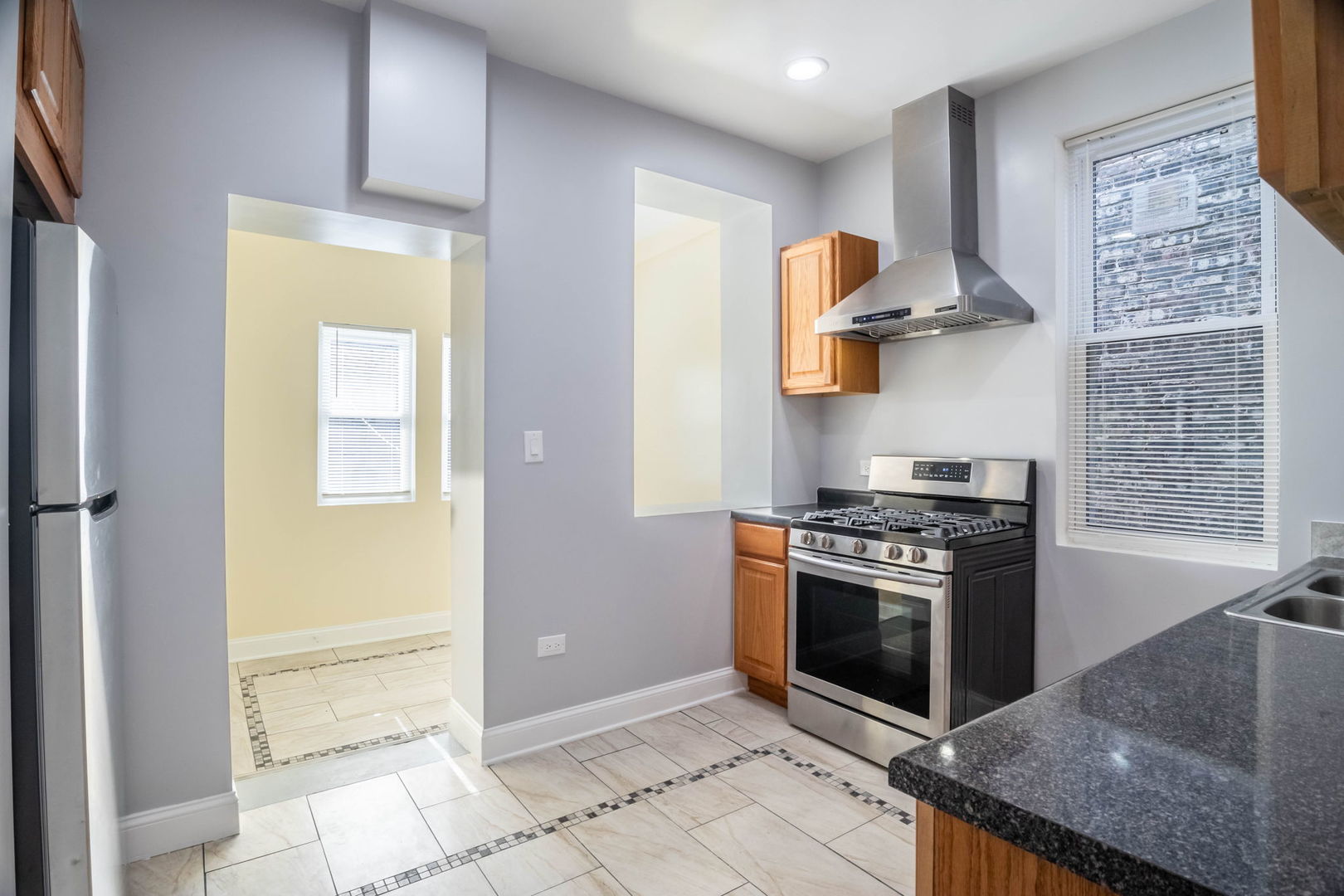 4837 West Monroe Street, Unit 1 Chicago, IL 60644 - Photo 18 of 21 a kitchen with stainless steel appliances granite countertop a stove and a refrigerator