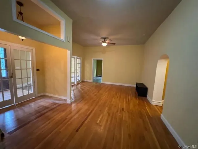 a view of a big room with wooden floor and windows