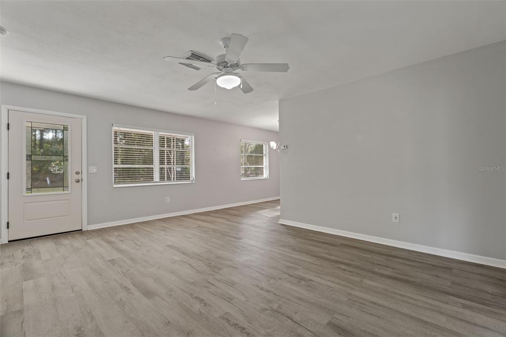 410 Daisy Lane Inverness, FL 34452 - Photo 13 of 37 a view of an empty room with wooden floor and a window