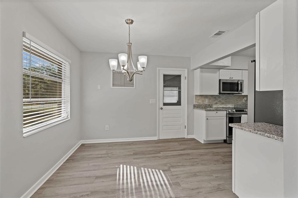 410 Daisy Lane Inverness, FL 34452 - Photo 14 of 37 a view of a kitchen with a stove wooden floor wooden floor and a kitchen