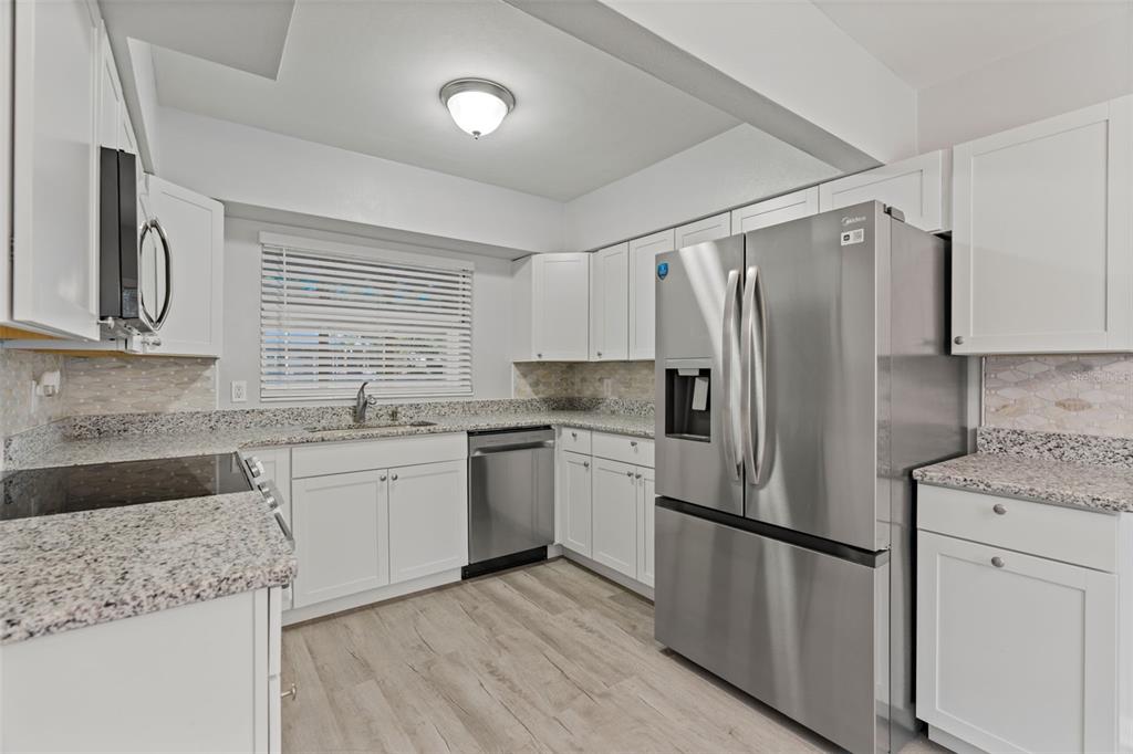 410 Daisy Lane Inverness, FL 34452 - Photo 16 of 37 a kitchen with stainless steel appliances granite countertop a refrigerator sink and stove