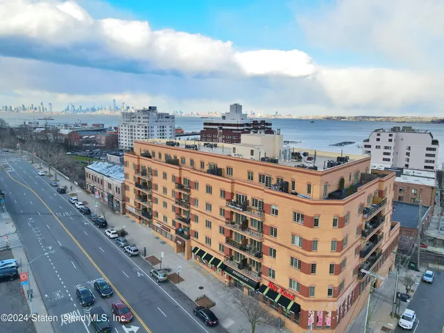 a kitchen with stainless steel appliances granite countertop a refrigerator a stove a sink a dining table and chairs with wooden floor