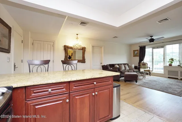 a living room with furniture a flat screen tv and kitchen view