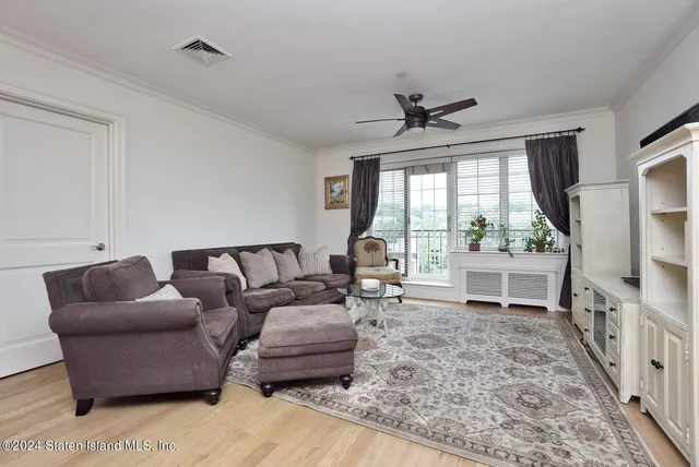 a living room with furniture a large window and a flat screen tv