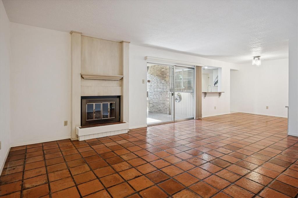 5148 Amesbury Drive, Unit 121 Dallas, TX 75206 - Photo 1 of 1 a big room with windows and a fireplace