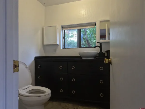 a bathroom with a granite countertop toilet sink and mirror