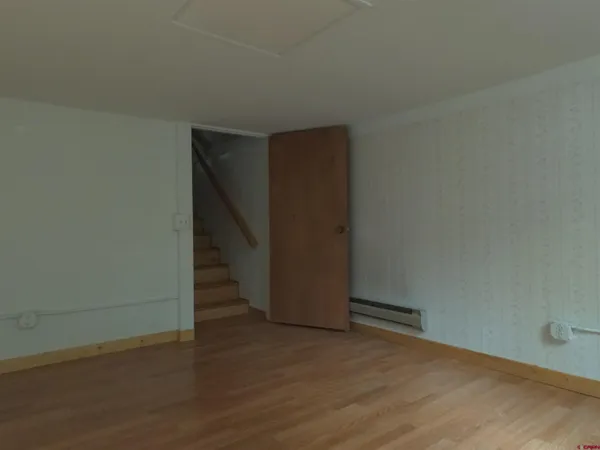 an empty room with wooden floor and closet