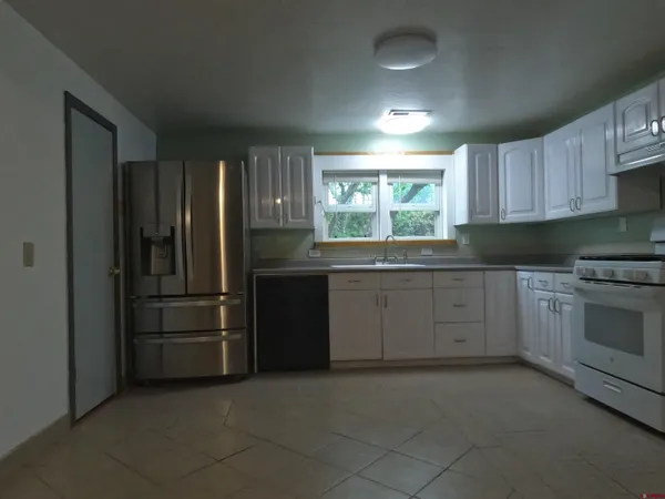 a kitchen with stainless steel appliances granite countertop a refrigerator and a sink