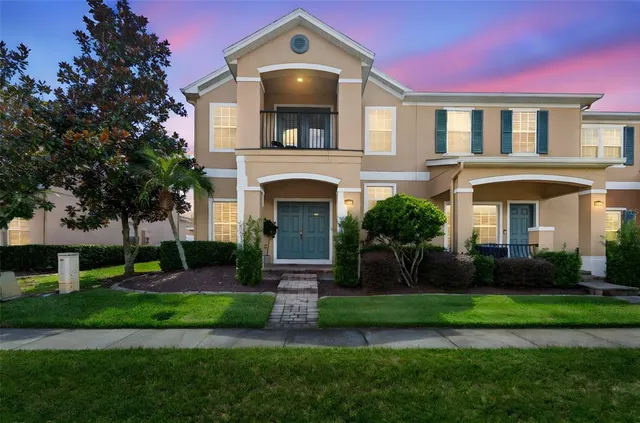 a front view of a house with garden and trees