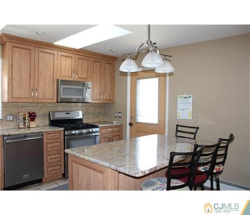 20 Dover Road Colonia, NJ 07067 - Photo 3 of 19 a kitchen with a stove a sink dishwasher and a microwave