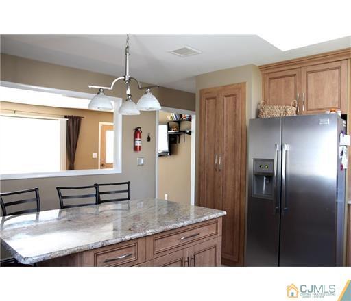 20 Dover Road Colonia, NJ 07067 - Photo 9 of 19 a kitchen with stainless steel appliances kitchen island granite countertop a refrigerator and a sink