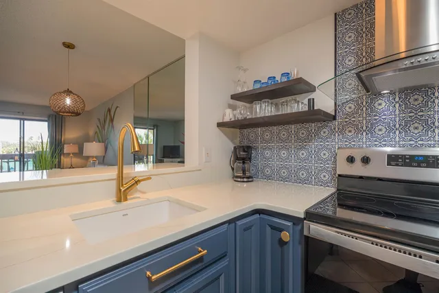 a kitchen with a sink and a stove next to a window