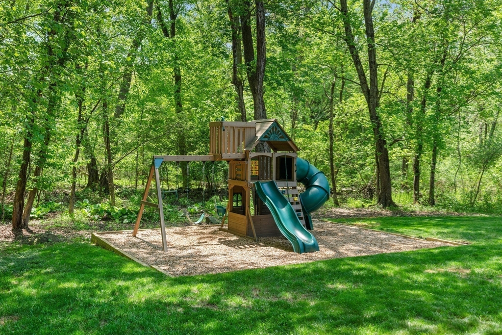 11 Longmeadow Road Medfield, MA 02052 - Photo 31 of 39 a view of a backyard with a slide trees and wooden fence