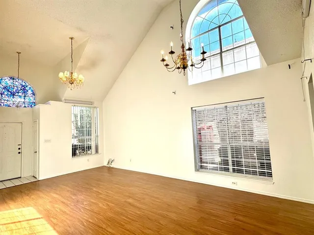 a view of an empty room with wooden floor and cabinet