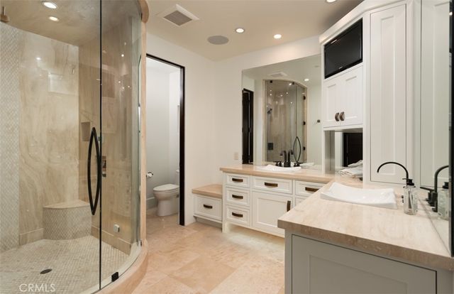 a bathroom with a double vanity sink a mirror and shower
