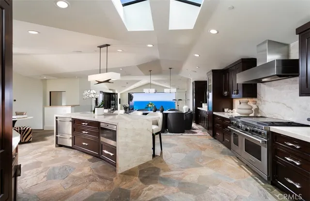 a kitchen with stainless steel appliances kitchen island granite countertop a stove and a sink