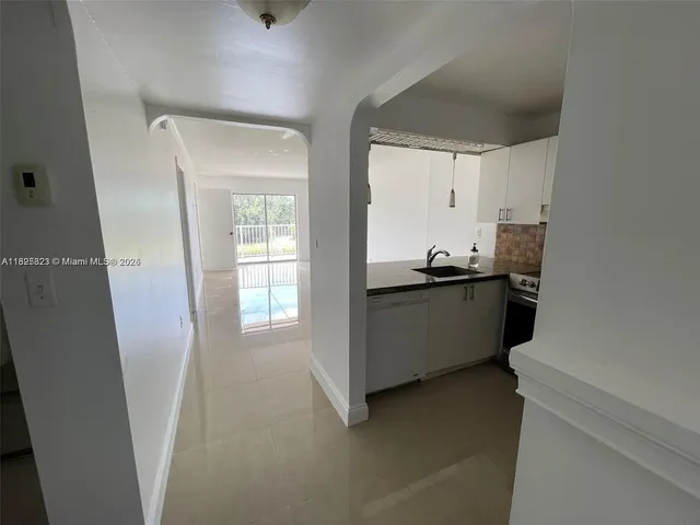 a kitchen with granite countertop a sink and cabinets