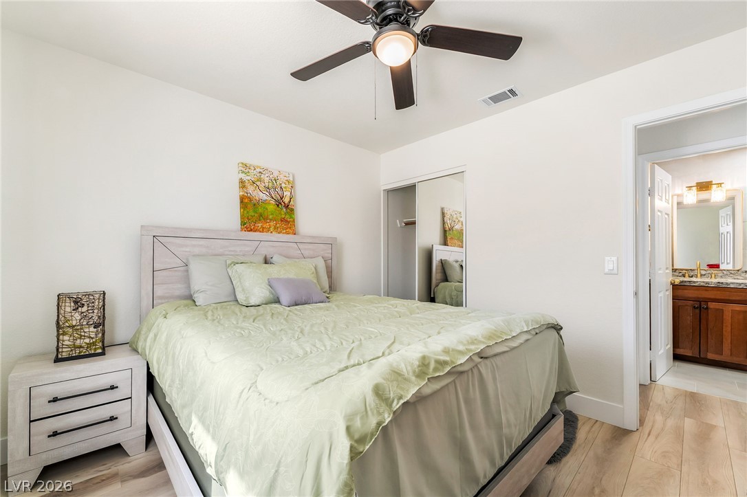 104 Appian Way Henderson, NV 89002 - Photo 12 of 24 Well-lit bedroom features wood-look flooring and convenient access to the private bath.