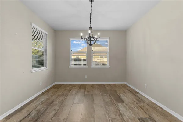 a view of a room with wooden floor and chandelier