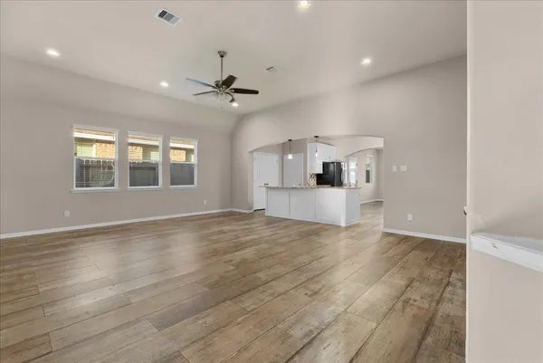 a view of empty room with wooden floor and windows
