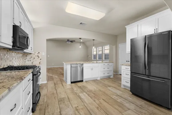 a kitchen with stainless steel appliances a refrigerator sink and microwave