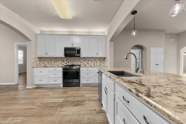a kitchen with stainless steel appliances granite countertop a stove and a sink
