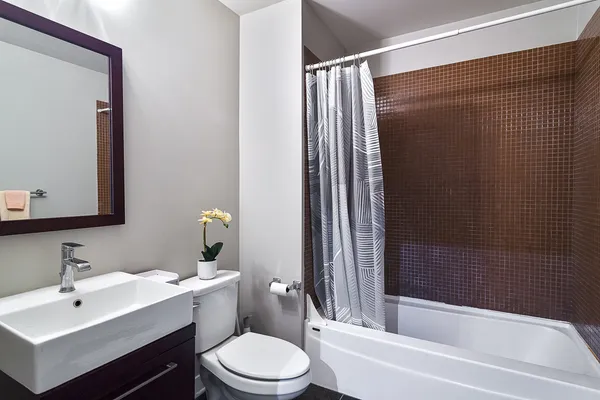 a bathroom with a bathtub shower sink vanity and toilet