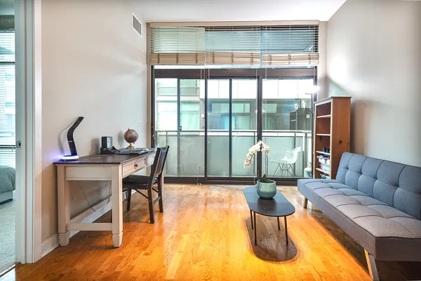 a living room with furniture a flat screen tv and a floor to ceiling window