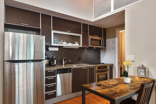 a kitchen with stainless steel appliances granite countertop a refrigerator stove top oven and sink
