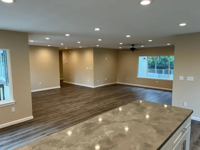 an empty room with wooden floor and windows