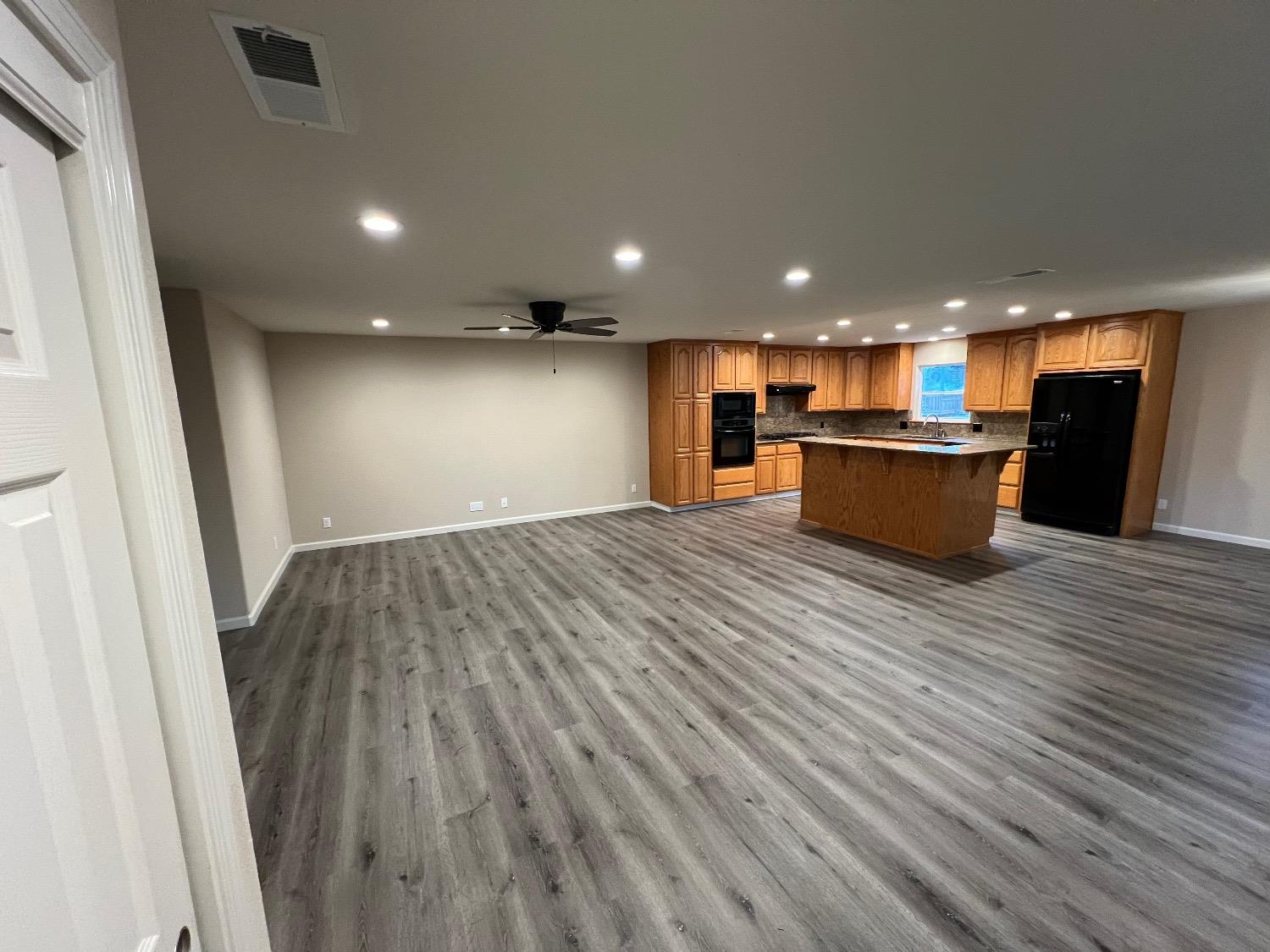 10016 South Priest Road French Camp, CA 95231 - Photo 29 of 63 a open kitchen with kitchen island a sink dishwasher stove and wooden floors