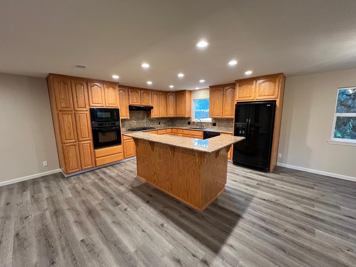 10016 South Priest Road French Camp, CA 95231 - Photo 31 of 63 a large kitchen with stainless steel appliances granite countertop a large counter top and wooden floors