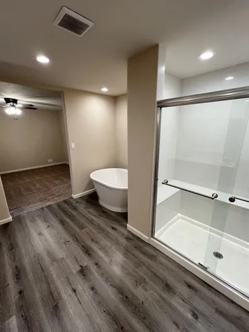 a view of an empty room with a chandelier fan