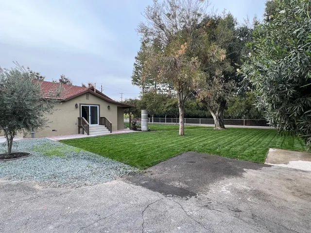 a front view of a house with yard and green space