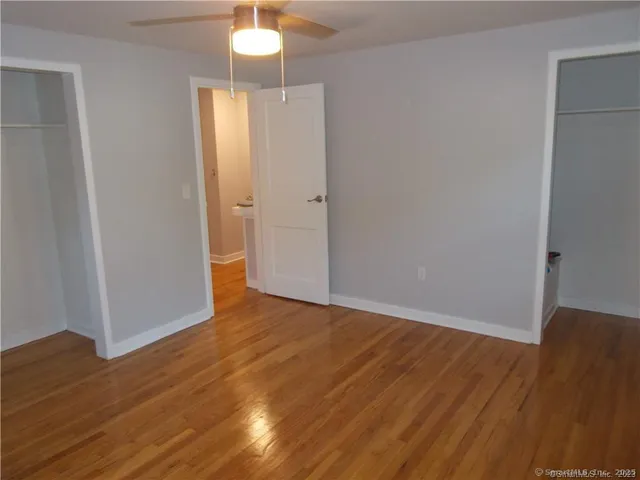 a view of a hallway with wooden floor and closet