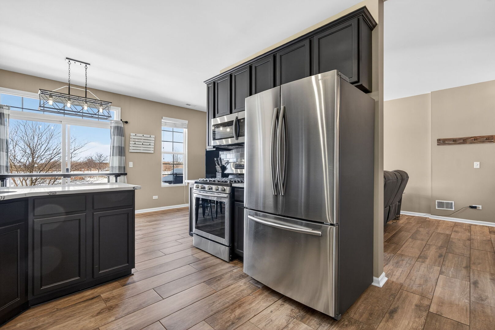15238 Kenmare Circle Manhattan, IL 60442 - Photo 3 of 29 a kitchen with granite countertop a refrigerator cabinets and wooden floor