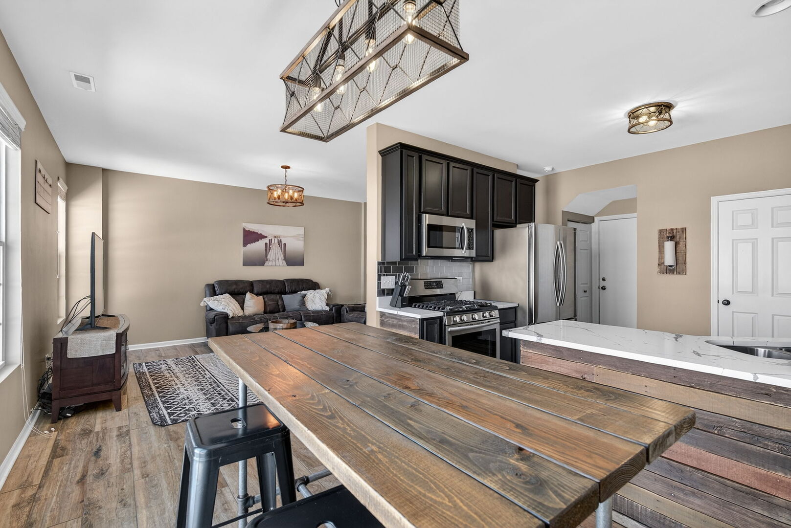 15238 Kenmare Circle Manhattan, IL 60442 - Photo 7 of 29 a living room with furniture a flat screen tv and kitchen view