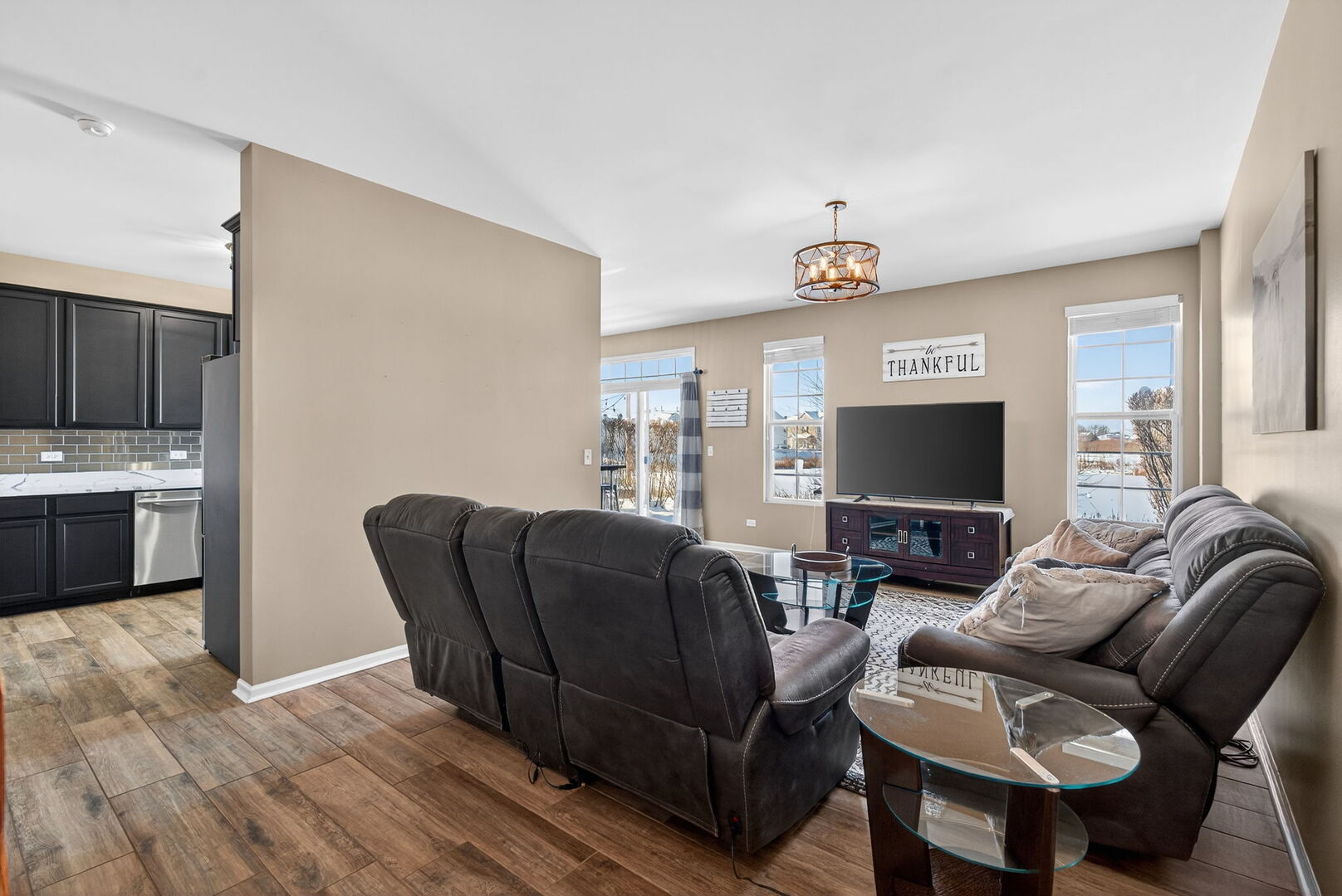15238 Kenmare Circle Manhattan, IL 60442 - Photo 10 of 29 a living room with furniture a flat screen tv and kitchen view