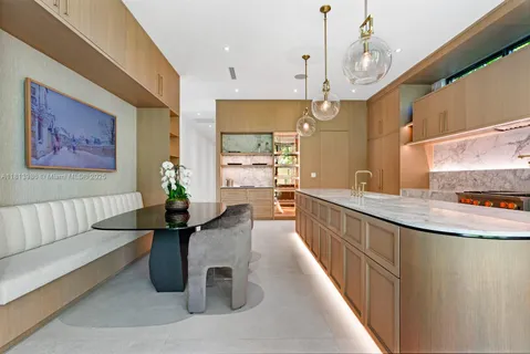a large kitchen with kitchen island a large counter top a sink a stove and a refrigerator