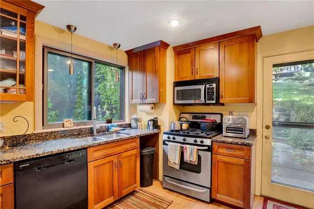 a kitchen with stainless steel appliances a stove sink and microwave