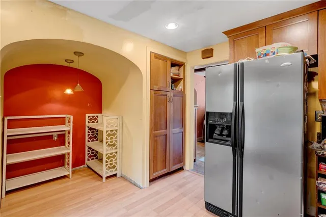 a metallic refrigerator freezer sitting inside of a kitchen