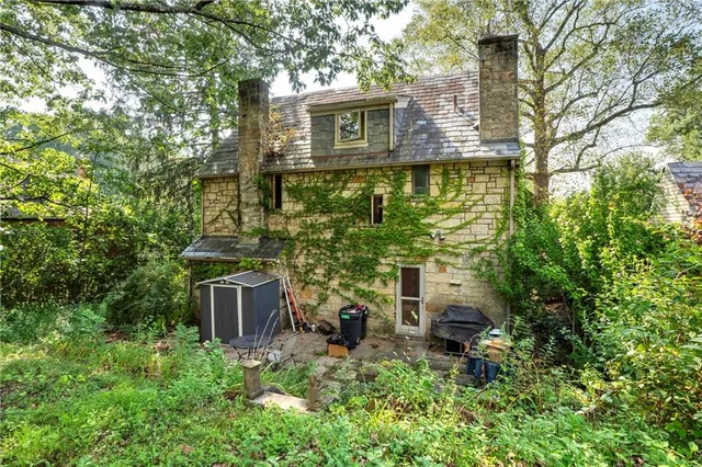 a aerial view of a house with large trees and plants