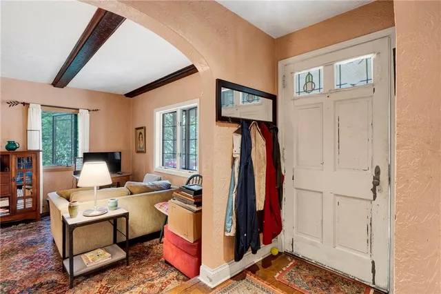 a living room with furniture a window and a flat screen tv