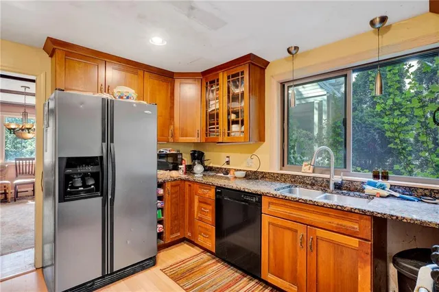 a kitchen with stainless steel appliances granite countertop a refrigerator and a sink