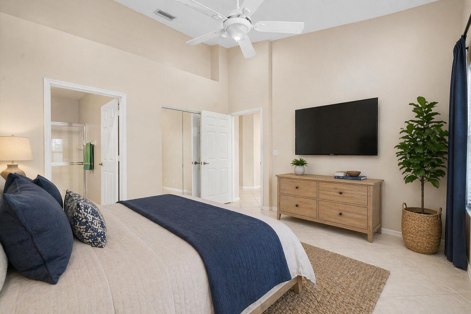 6060 Petunia Road Delray Beach, FL 33484 - Photo 18 of 59 a bedroom with a bed and a flat screen tv in it