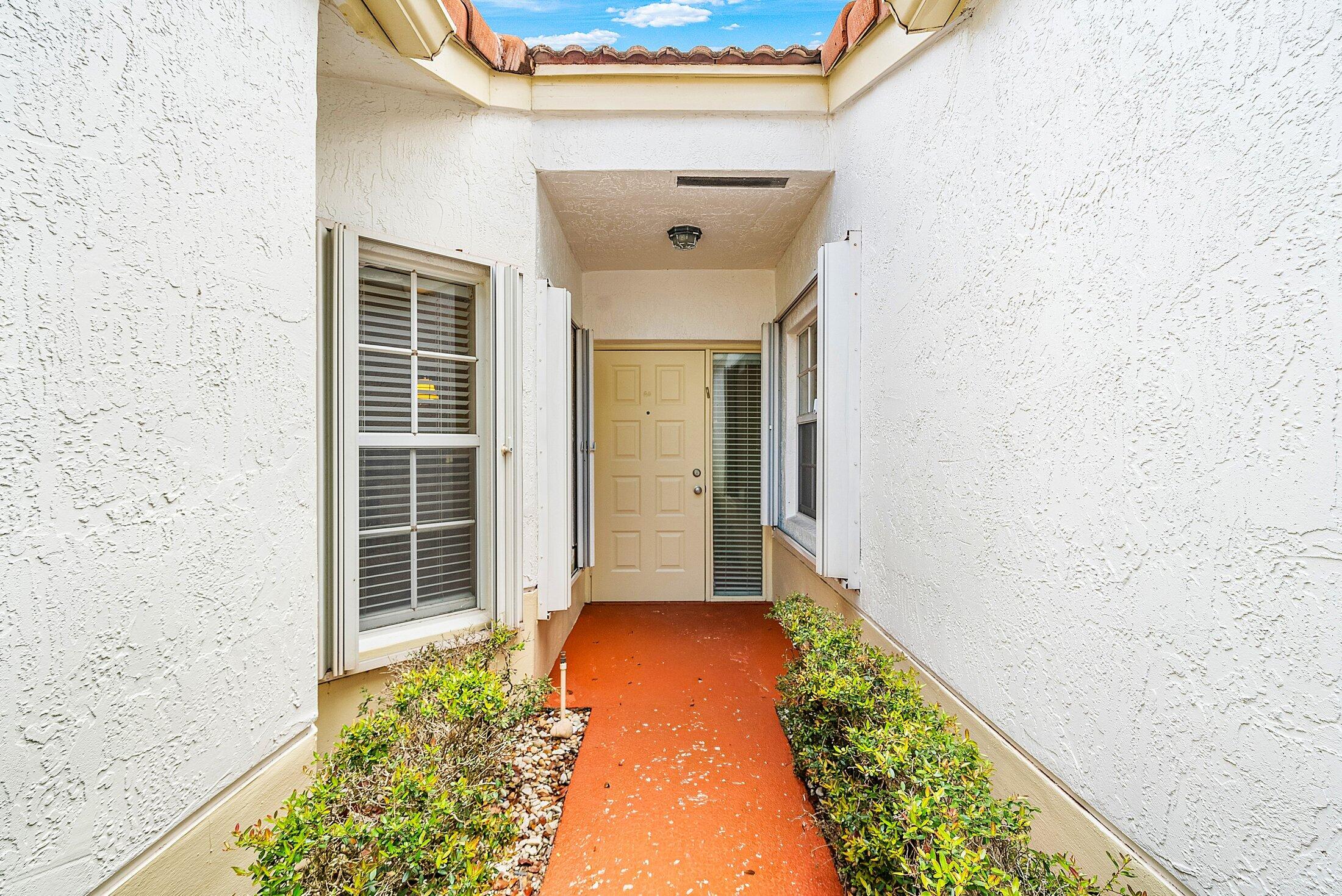 6060 Petunia Road Delray Beach, FL 33484 - Photo 3 of 59 front view of a house with a large window