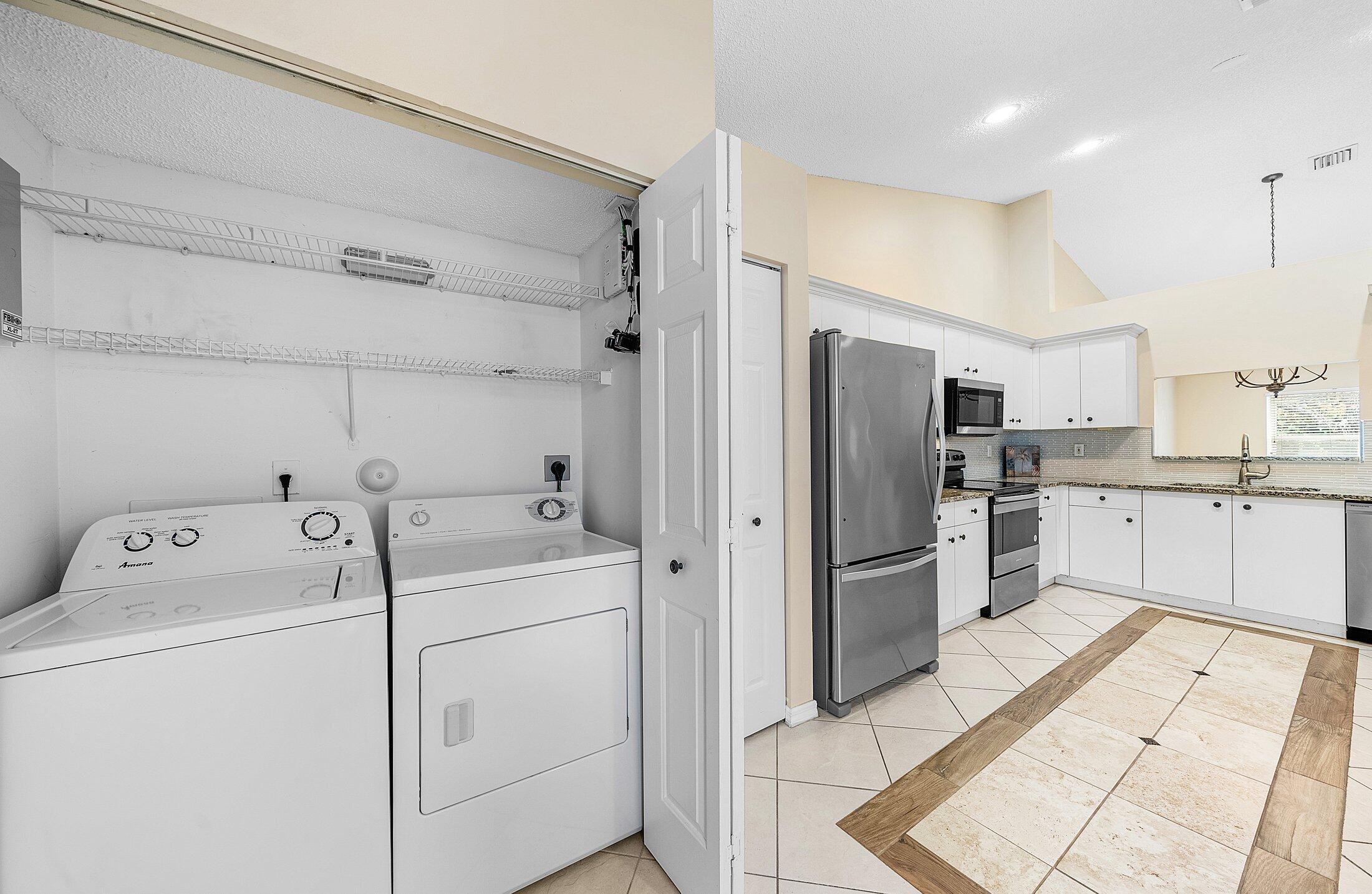 6060 Petunia Road Delray Beach, FL 33484 - Photo 31 of 59 a kitchen with a refrigerator sink and cabinets