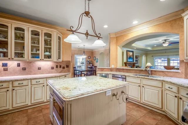 a kitchen with a stove a sink a chandelier and dining table