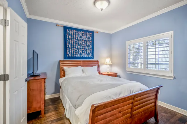 a bedroom with a bed and wooden floor