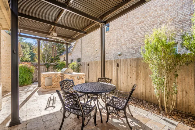 a roof deck with table and chairs and potted plants